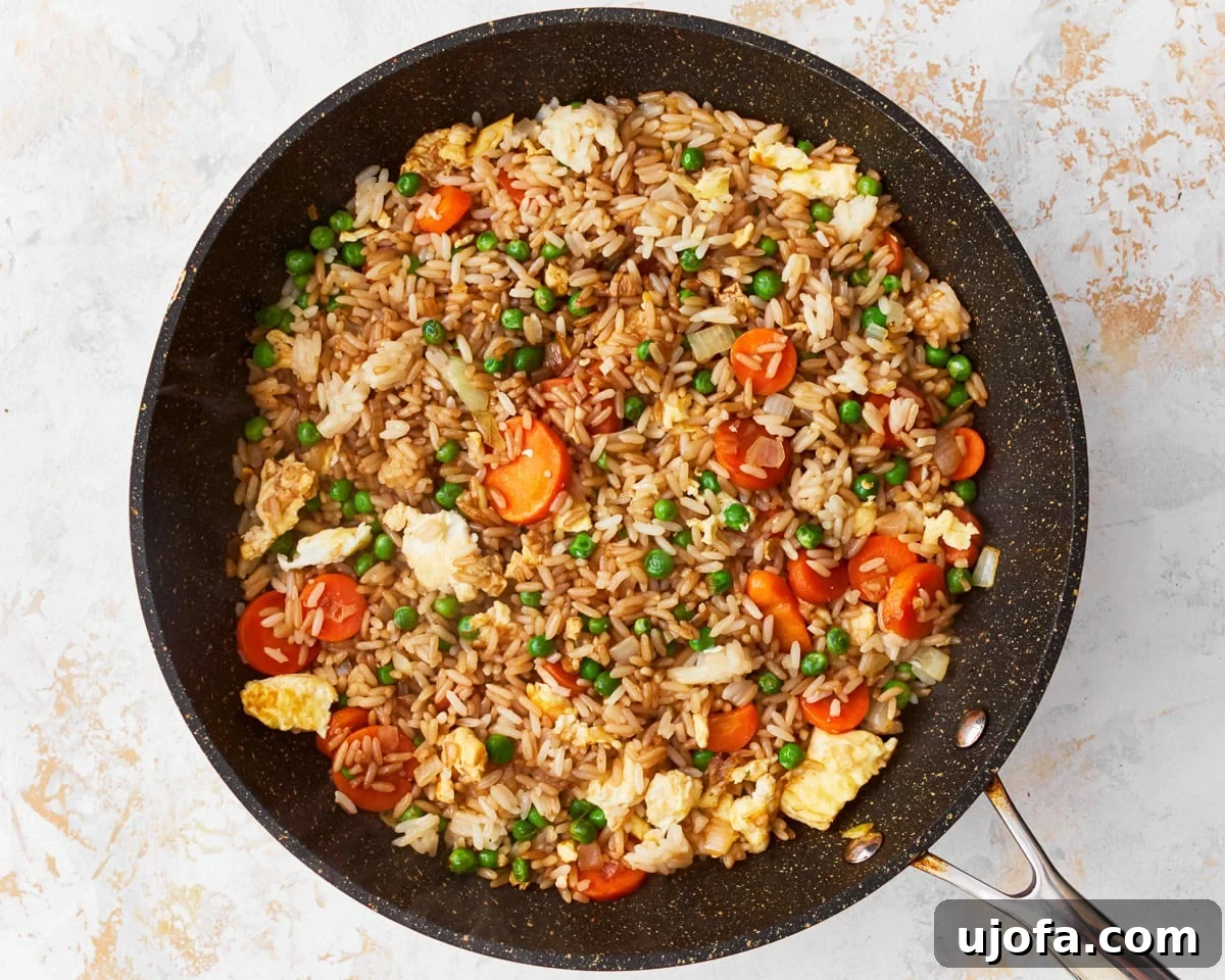 Your New Favorite Gluten-Free Fried Rice 10 Toasted sesame oil and gluten-free soy sauce being poured over the fried rice in a skillet.