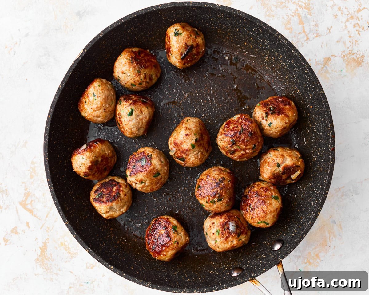 Delicious Gluten-Free Turkey Meatballs 10 Gluten-free turkey meatballs cooking in a pan