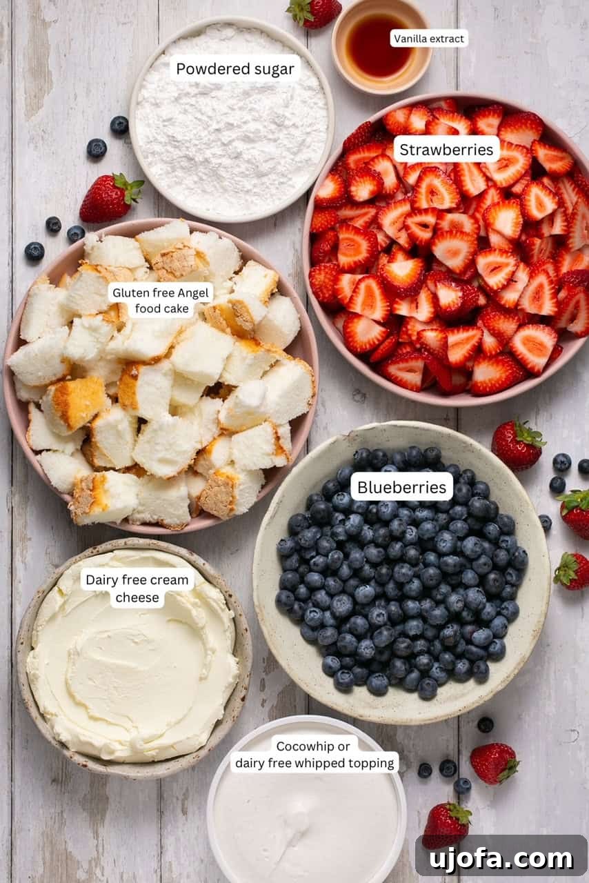 Various fresh ingredients laid out for making a gluten-free angel food cake trifle, including fresh berries, dairy-free cream cheese, and whipped topping