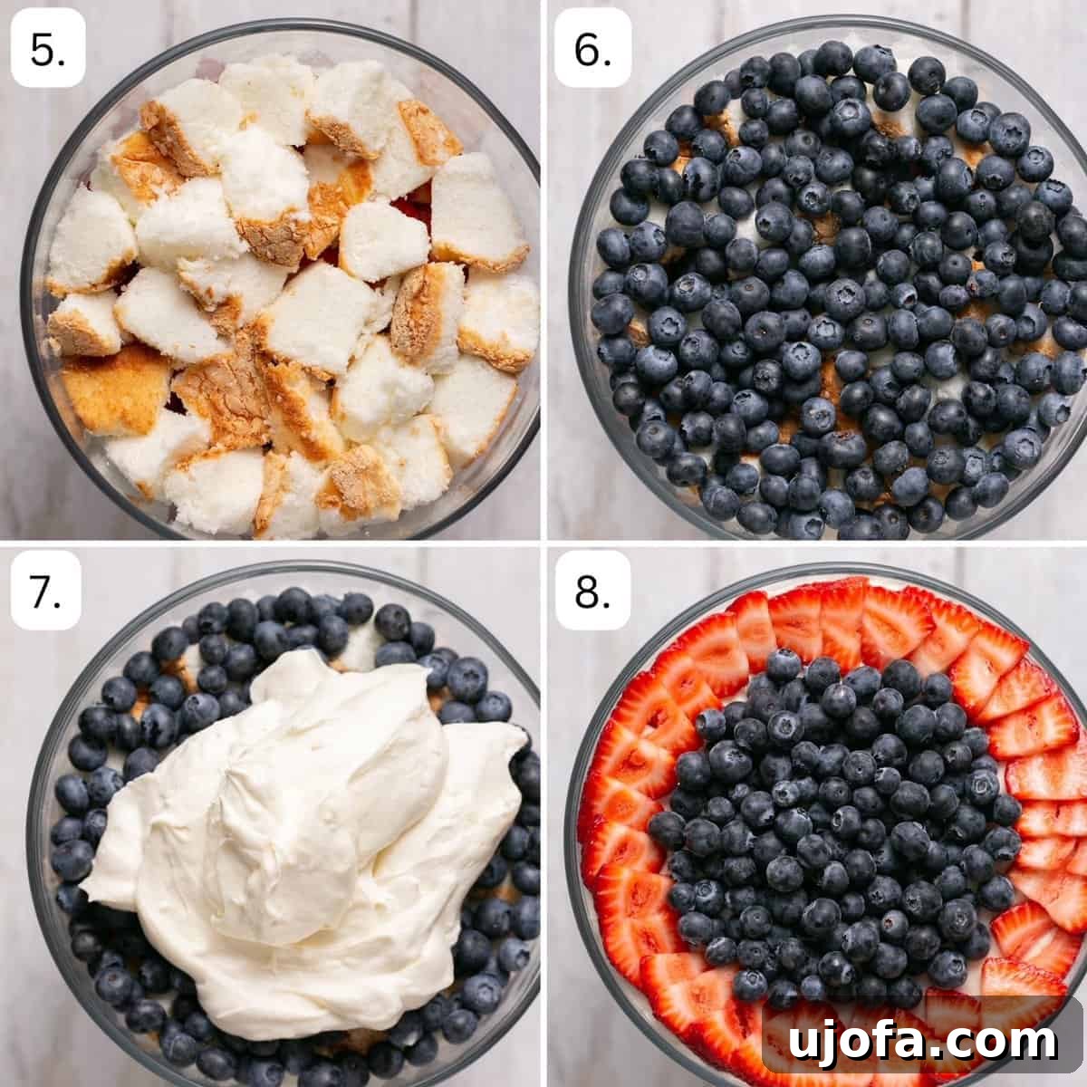 Half-assembled gluten-free trifle showing distinct layers of cake, fresh blueberries, creamy dairy-free topping, and sliced strawberries in a glass bowl