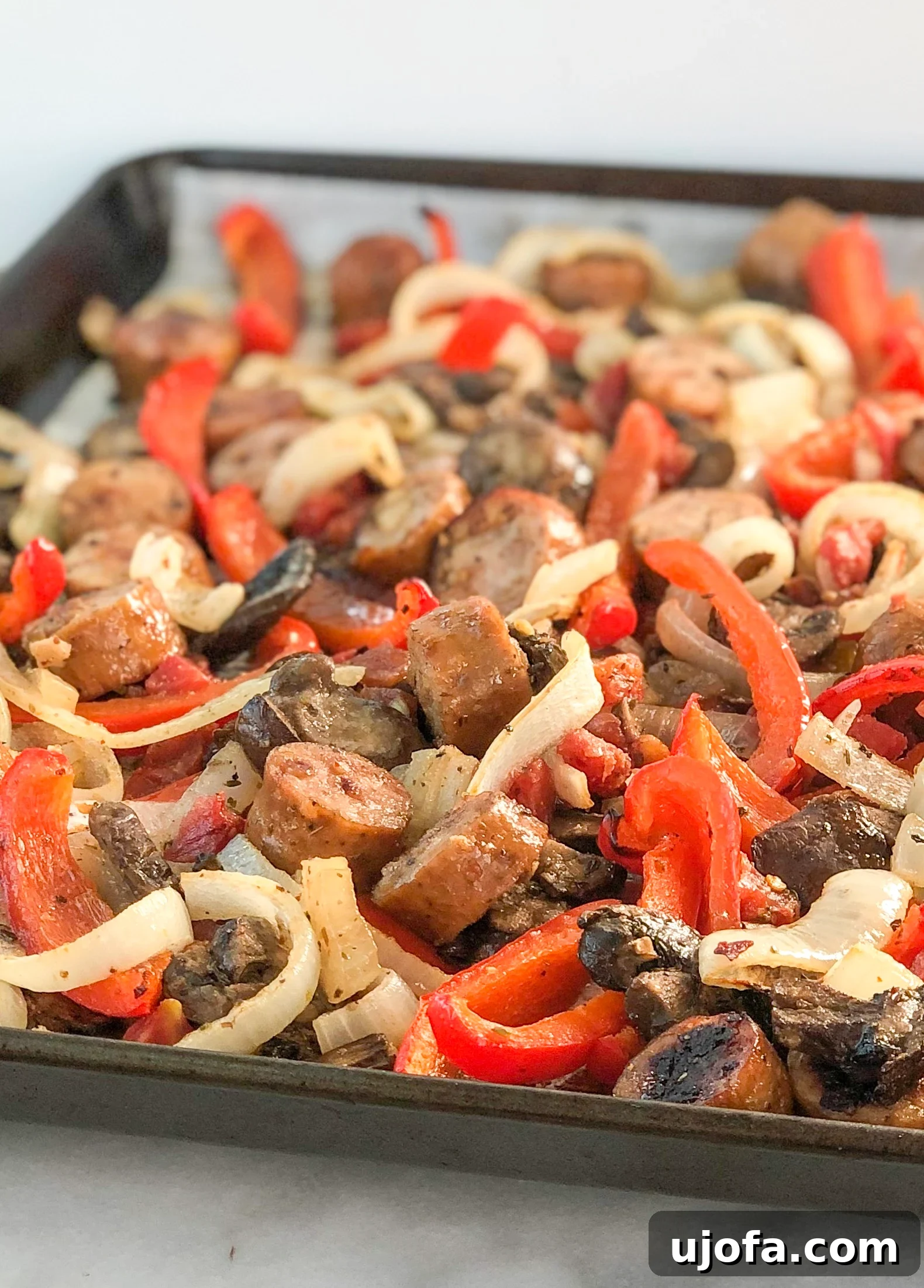 One Pan Roasted Italian Sausage and Peppers 3 Close-up of cooked Italian sausage and colorful bell peppers on a sheet pan.