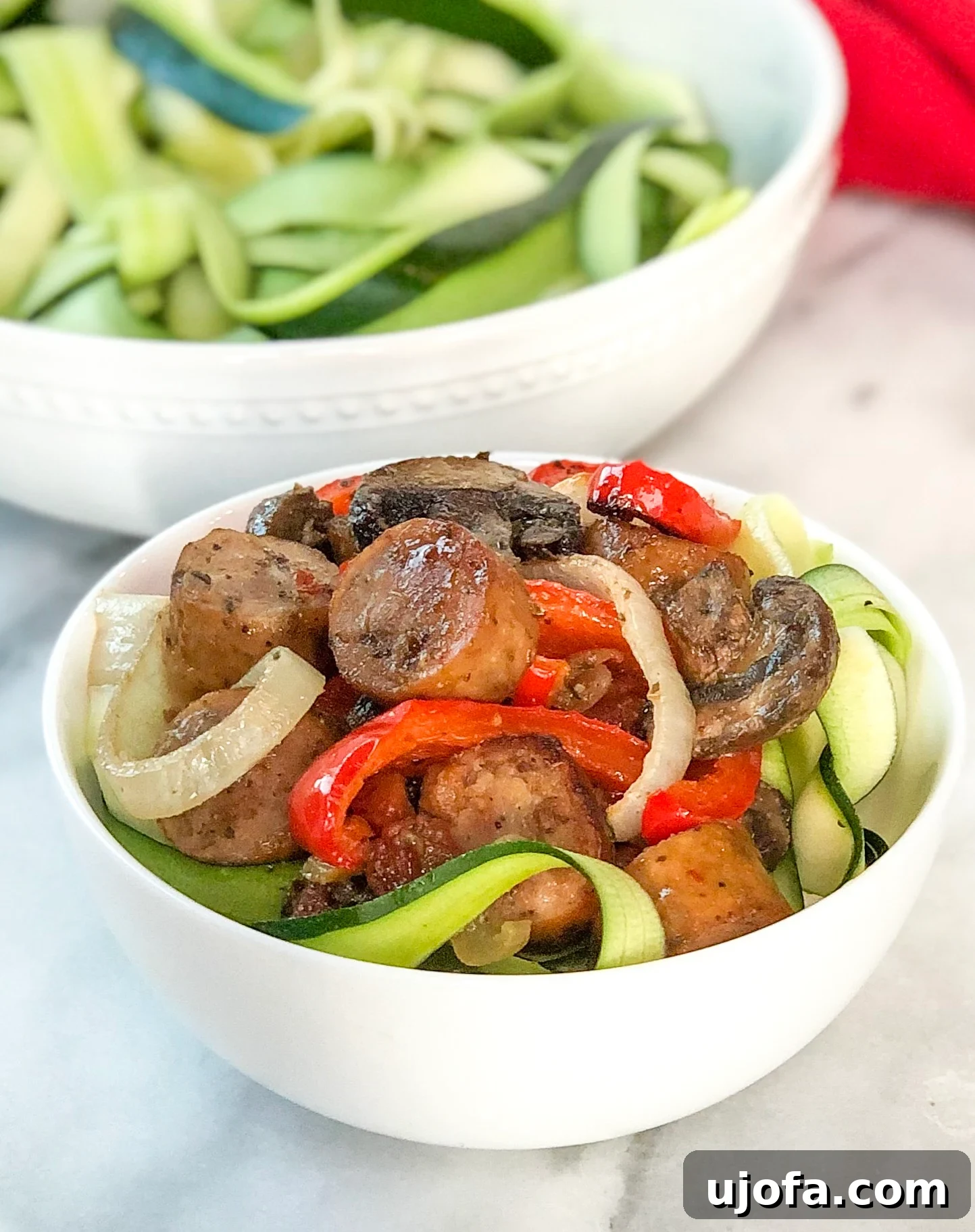 One Pan Roasted Italian Sausage and Peppers 5 Finished Sheet Pan Italian Sausage & Peppers with zucchini noodles on a plate.