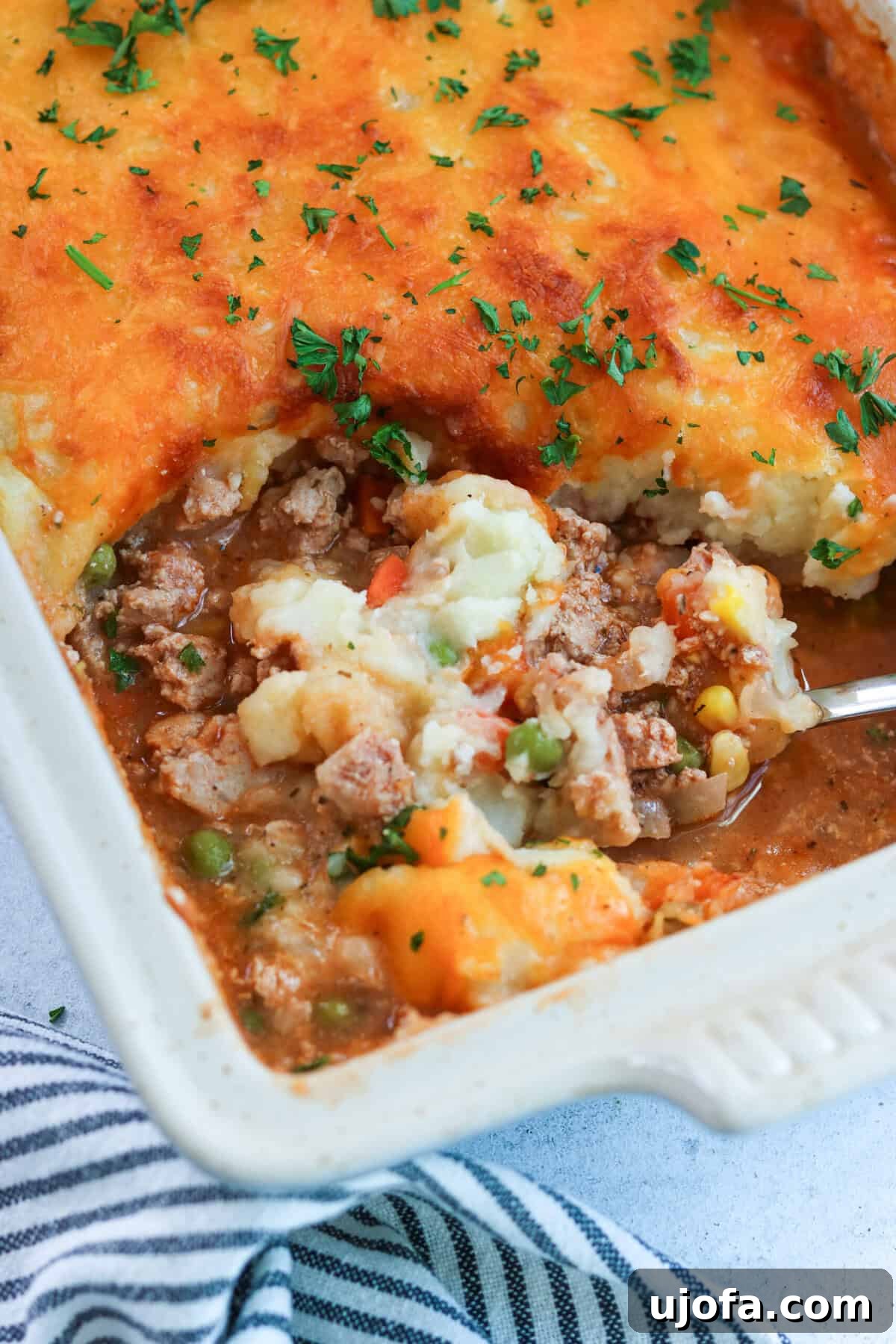 Savory Turkey Shepherd's Bake 2 ground turkey shepherd's pie in a casserole dish with a scoop being taken out