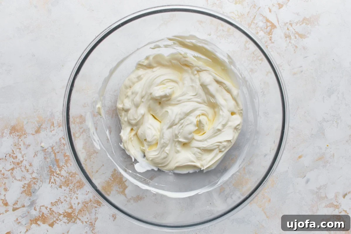 Velvety Warm Spinach Indulgence 7 cream cheese and sour cream mixture in glass bowl on light surface