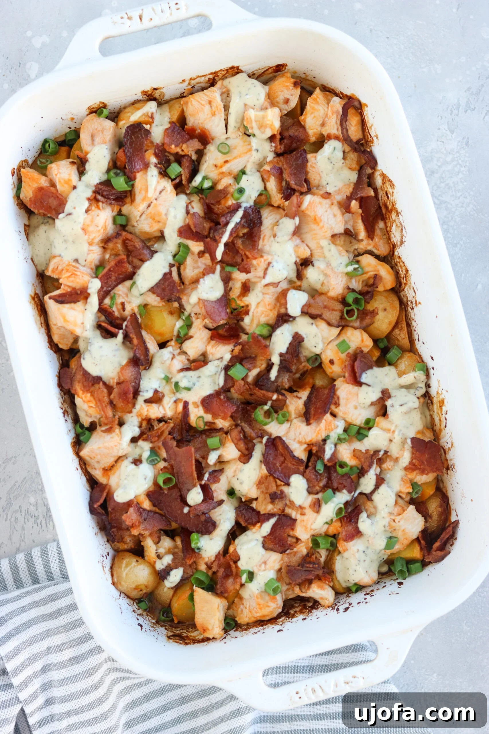 Hearty Whole30 Buffalo Chicken Loaded Potato Casserole 4 Whole30 buffalo chicken casserole generously drizzled with compliant ranch dressing, enhancing its rich flavors.