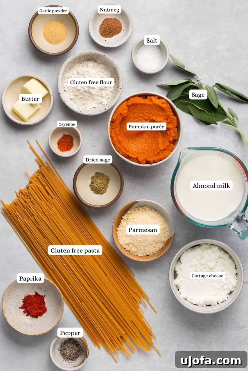 A collection of ingredients for pumpkin pasta sauce, displayed in various nesting bowls on a wooden surface.