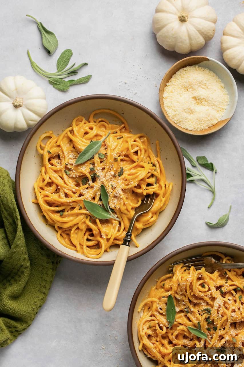 Two bowls of pumpkin pasta topped with fresh sage, ready to be served.