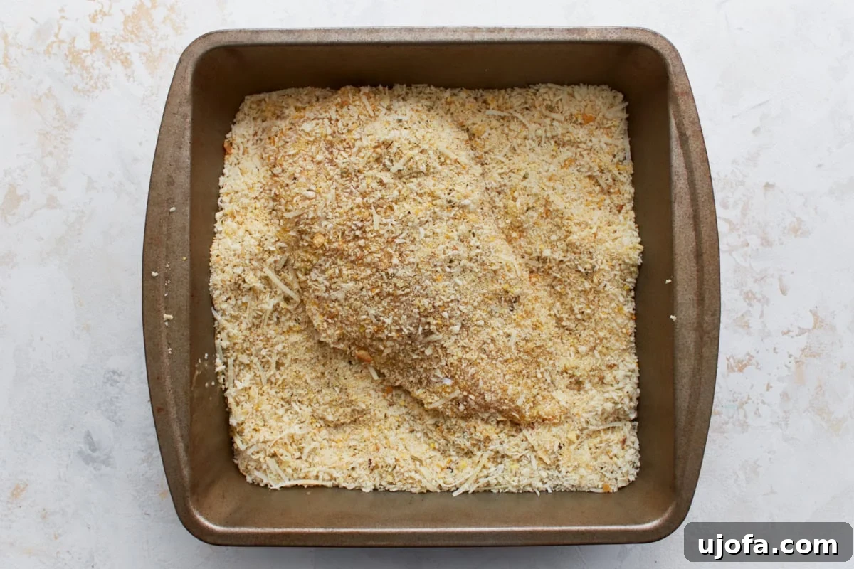 Irresistible Gluten-Free Chicken Parm 10 A chicken breast, now fully coated in the seasoned gluten-free breadcrumb mixture, ready for pan-frying.