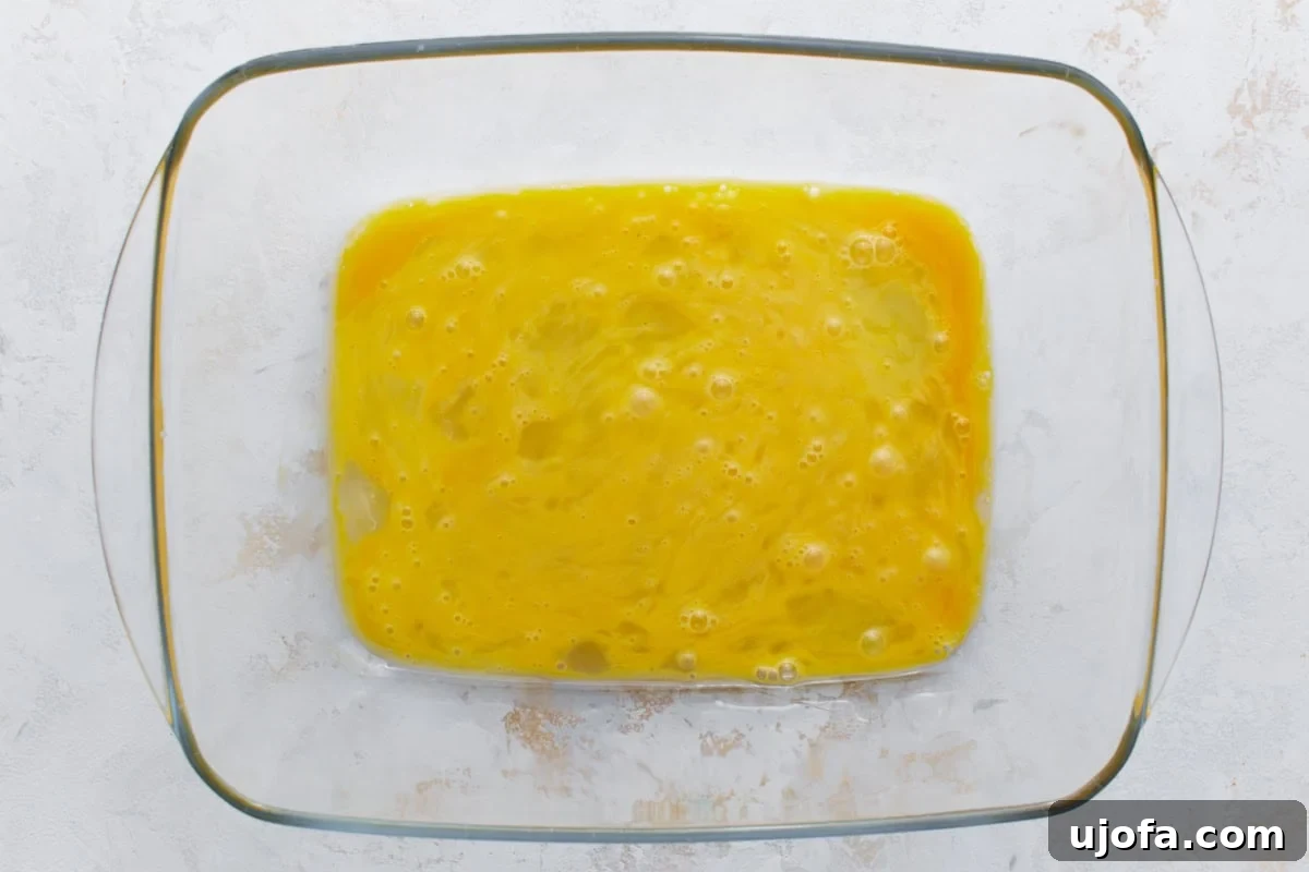 Irresistible Gluten-Free Chicken Parm 5 Whisked eggs in a clear glass pie pan, essential for dipping the chicken cutlets.