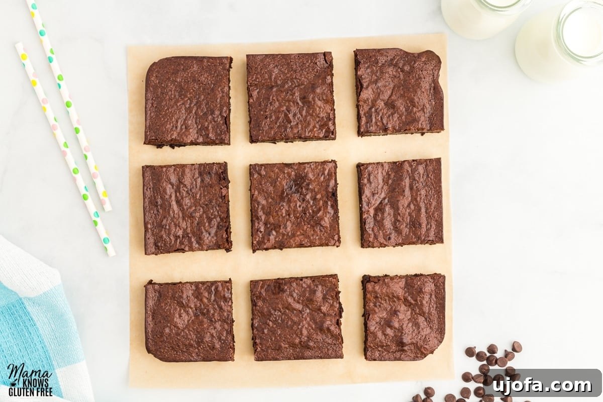Fudgy Flourless Delights 4 flourless brownies on a cutting board with milk and chocolate chips in the background