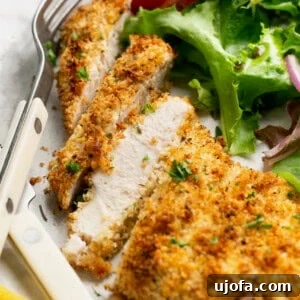 Sliced air fryer chicken cutlet on a plate with salad