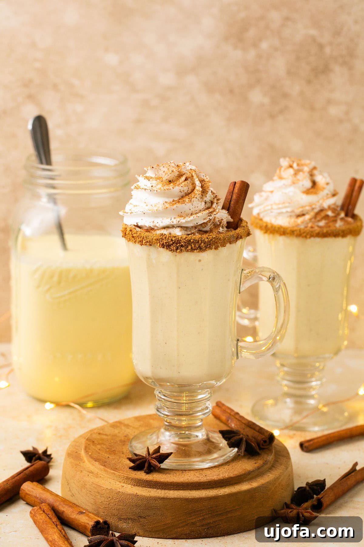 Plant-Based Eggnog 2 Creamy dairy-free eggnog served in a festive cup lined with cinnamon sugar, perfect for the holidays.