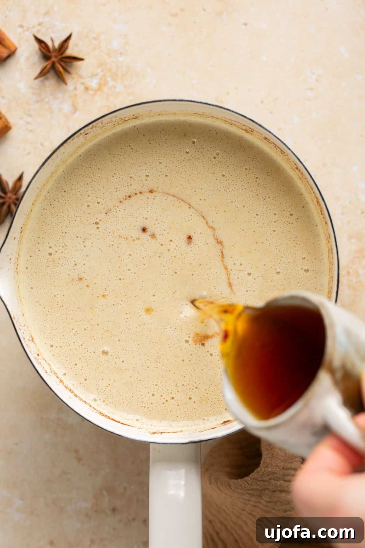 Plant-Based Eggnog 10 A stream of dark rum being poured into a pot of simmering dairy-free eggnog, adding a rich, festive kick.