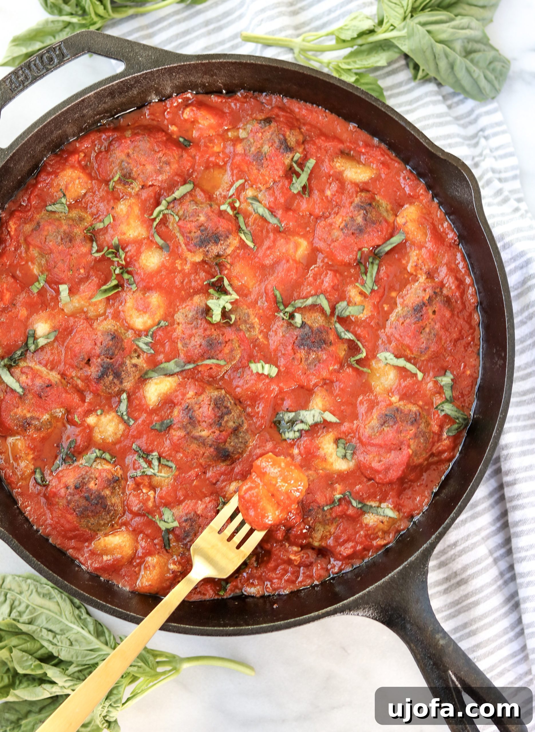 Skillet Pesto Meatball & Cauliflower Gnocchi Bake served with fresh basil