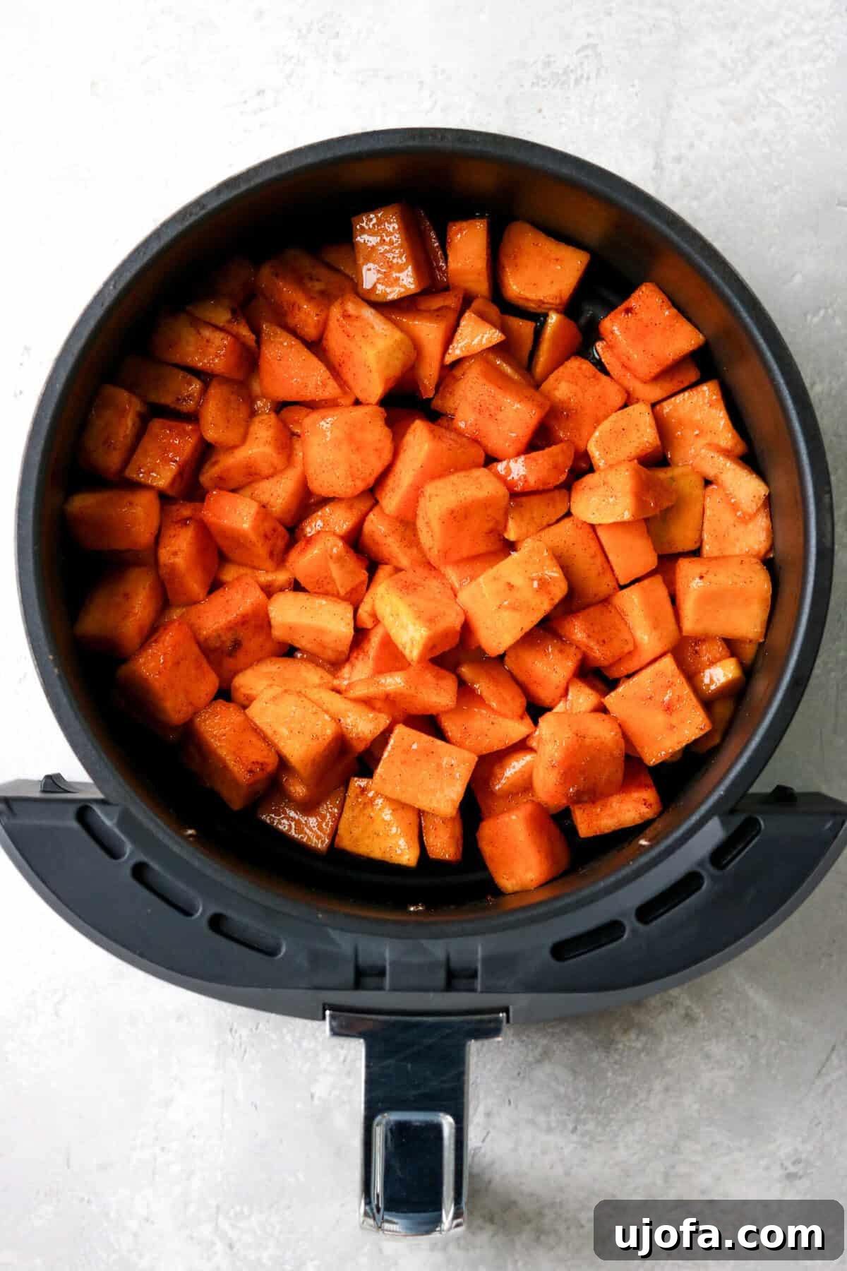 Effortless Air Fryer & Roasted Butternut Squash 5 Uncooked butternut squash cubes spread in an air fryer basket