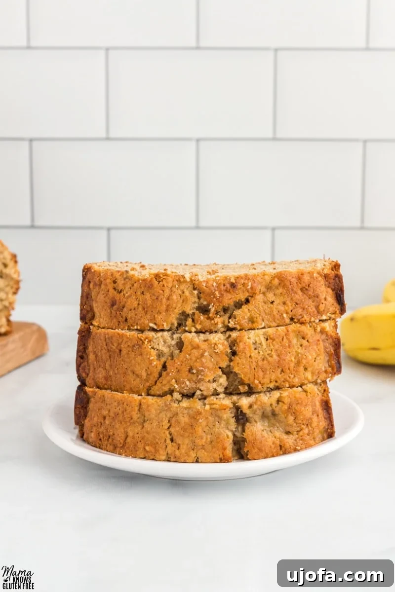 Three slices of Oat Flour Banana Bread stacked on white plate.