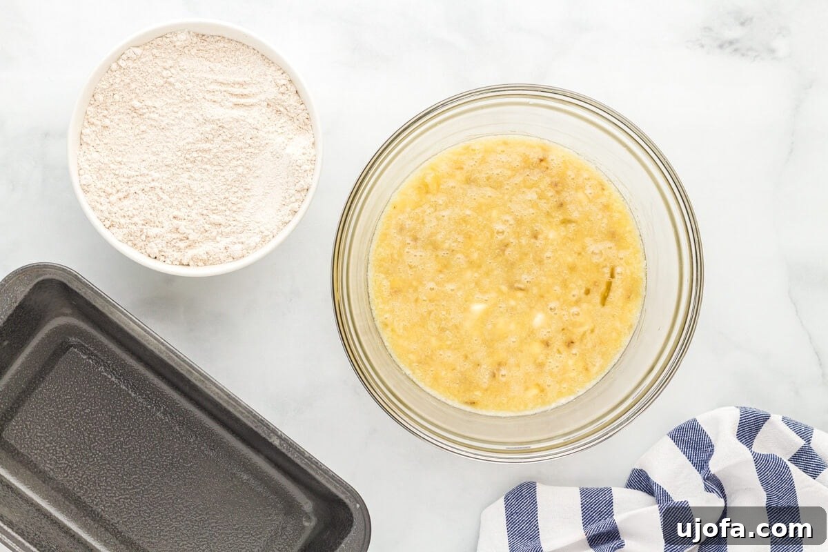 Gluten-free flour in one bowl, next to a bowl of mashed bananas mixed with eggs.