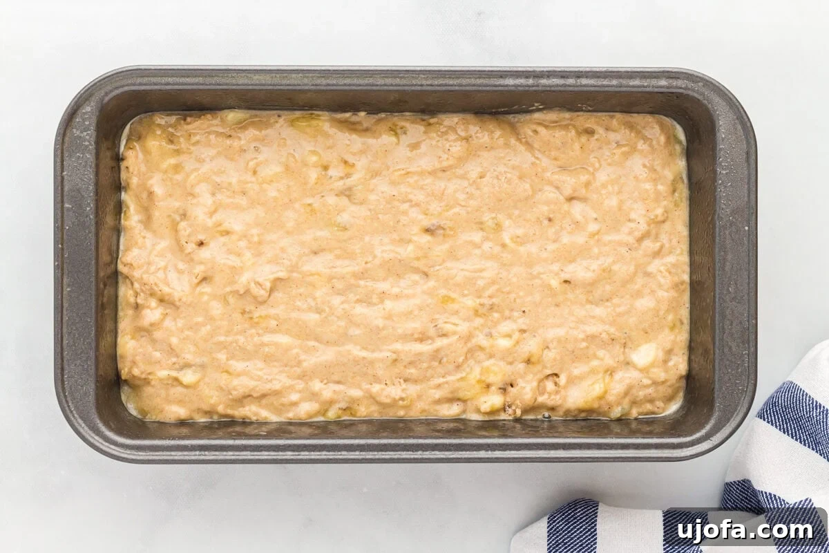 Oat flour banana bread batter poured into a loaf pan.
