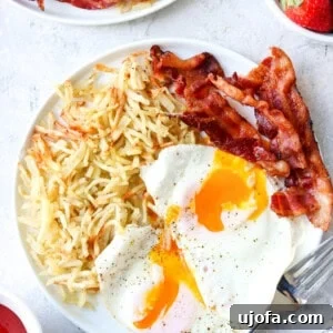 air fryer frozen hash browns on a plate with eggs and bacon