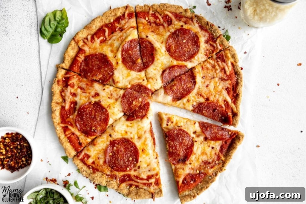 Crispy Gluten-Free Almond Flour Pizza Crust 2 Deliciously sliced pepperoni pizza with a golden-brown almond flour crust, garnished with fresh basil leaves on a wooden cutting board.