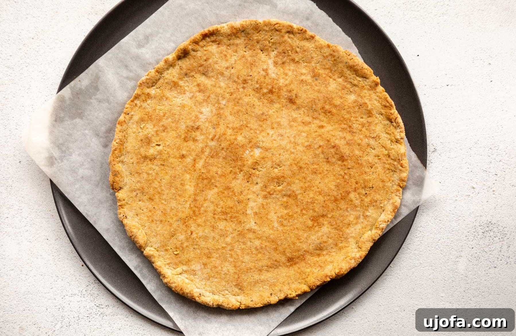 Crispy Gluten-Free Almond Flour Pizza Crust 11 A golden-brown, baked almond flour pizza crust removed from the oven, ready for toppings.