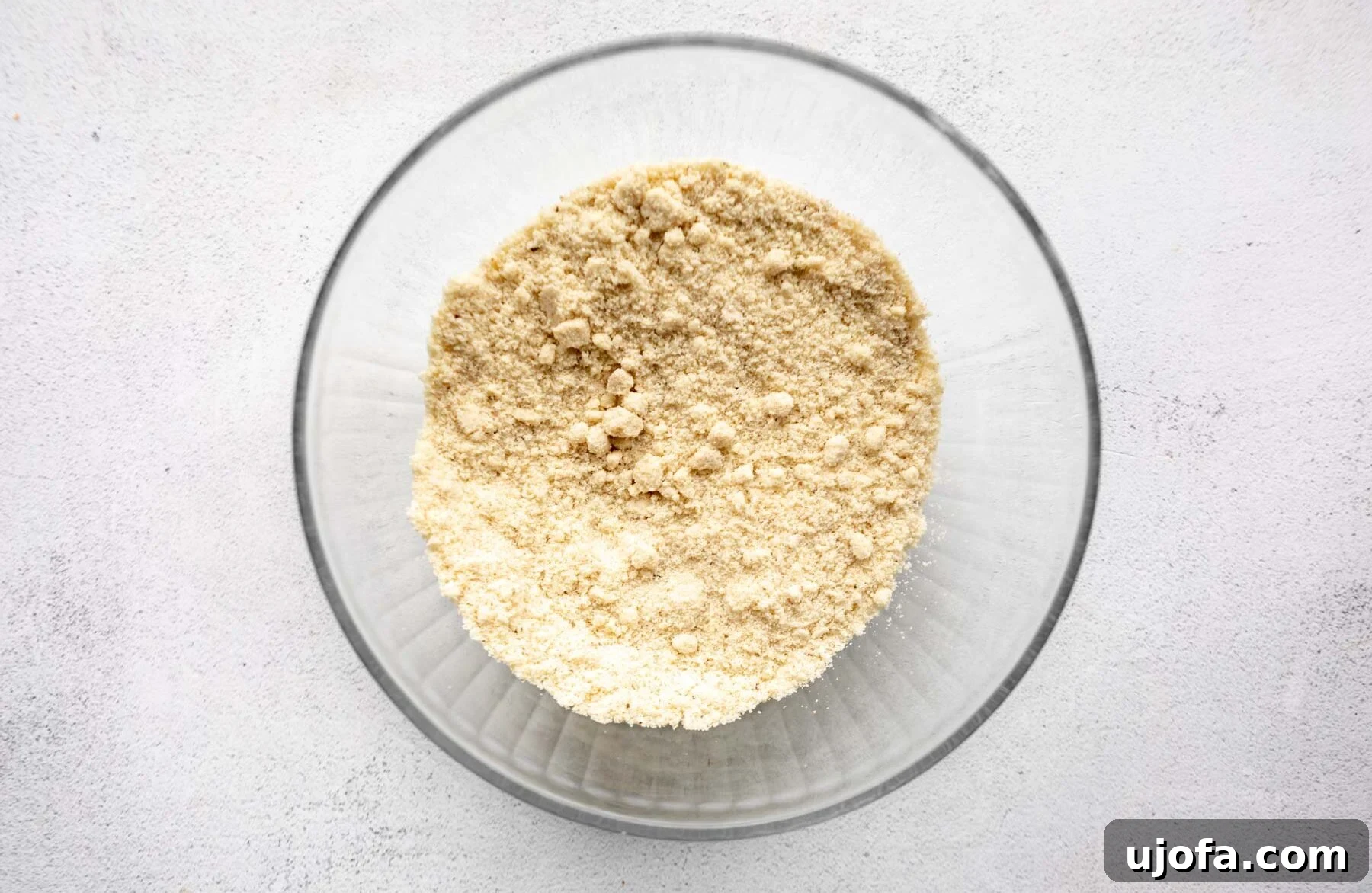 Crispy Gluten-Free Almond Flour Pizza Crust 7 A glass bowl filled with finely ground almond flour, ready for mixing with other ingredients.