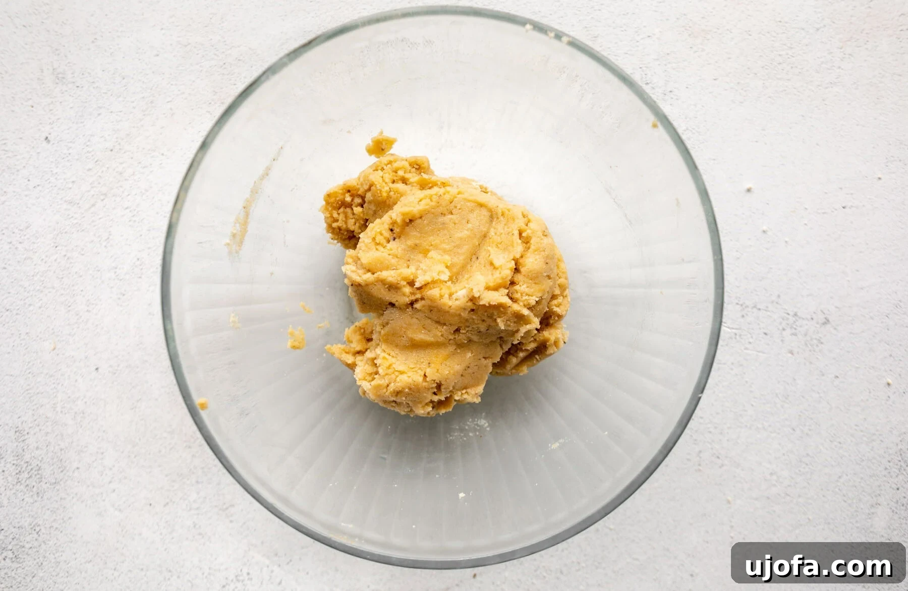Crispy Gluten-Free Almond Flour Pizza Crust 8 A ball of raw almond flour pizza dough resting in a glass bowl, showcasing its sticky, cohesive texture.