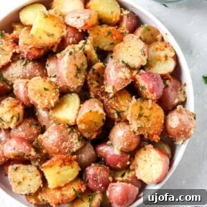 crispy parmesan potatoes in a while bowl with a side of sour cream