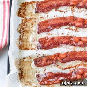 Perfectly baked bacon strips on a baking sheet.