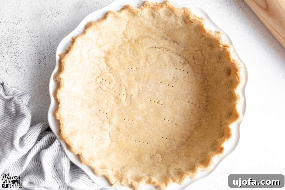 Gluten-Free Almond Flour Pie Crust in white pie plate with striped towel.
