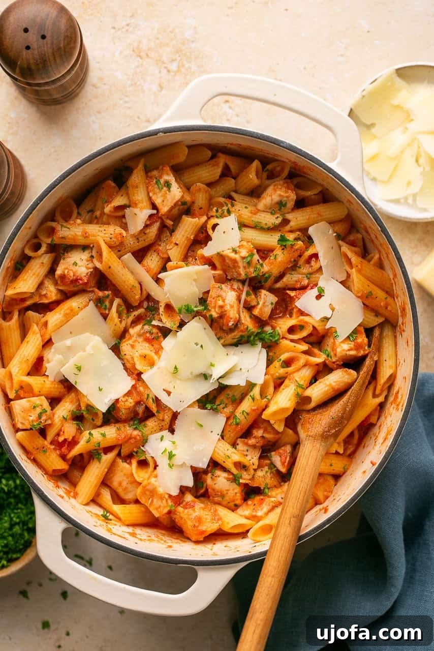 chicken and penne vodka in a pot topped with parmesan and parsley
