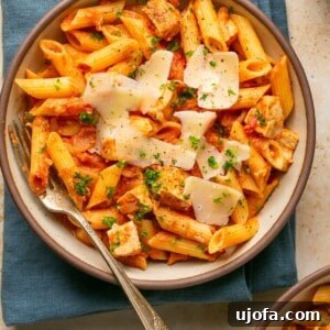 chicken and penne vodka in a bowl topped with parmesan and parsley