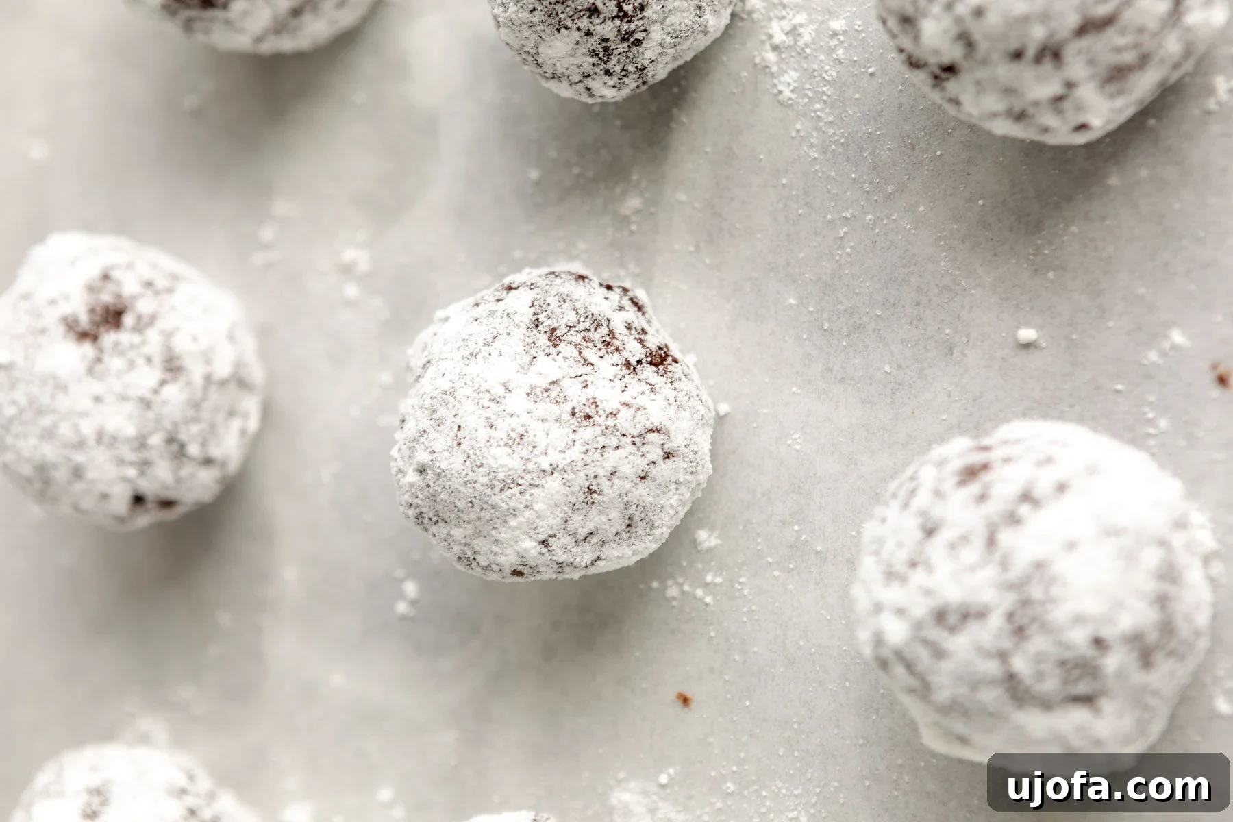Fudgy Chocolate Crinkle Cookies Gluten Free 10 Small balls of gluten-free chocolate crinkle cookie dough, generously coated in powdered sugar and ready for the oven.