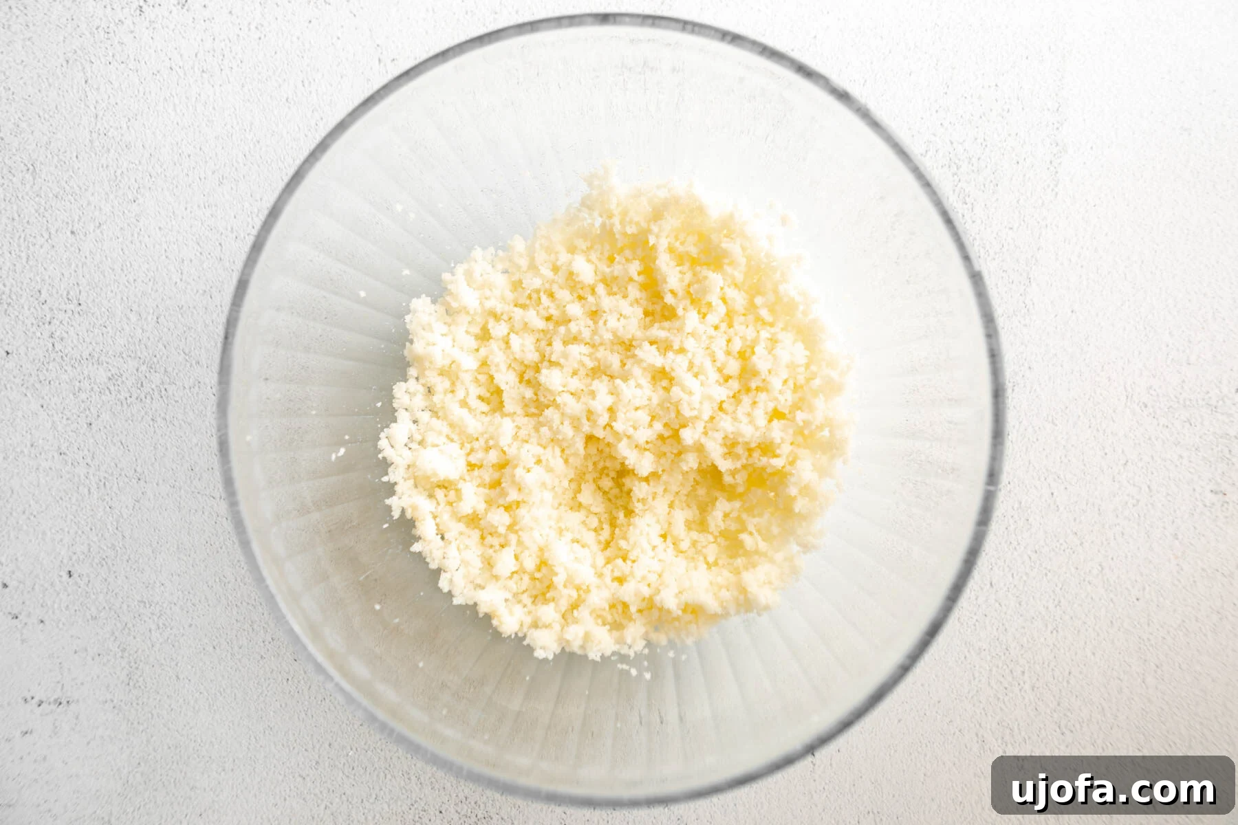 Fudgy Chocolate Crinkle Cookies Gluten Free 7 Butter and sugar being creamed together in a clear glass mixing bowl, a crucial first step for many cookie recipes.