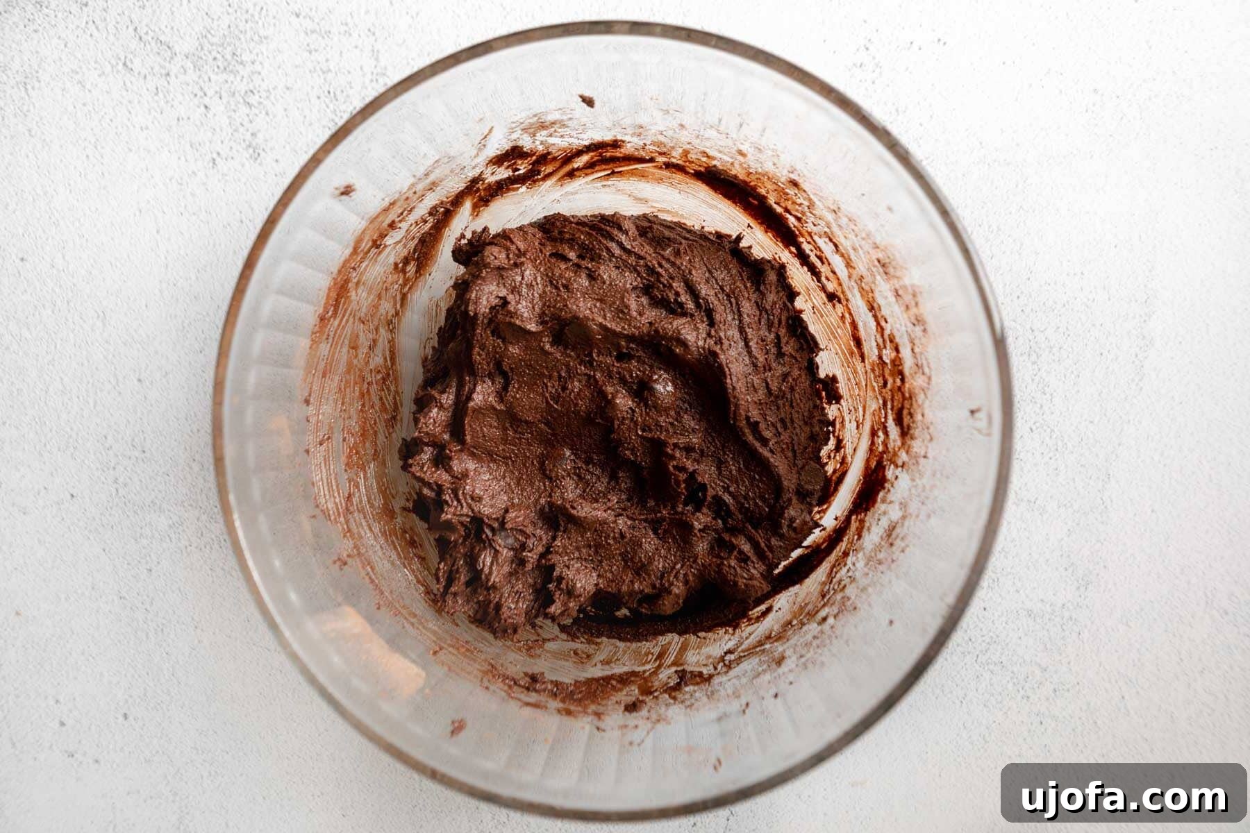 Fudgy Chocolate Crinkle Cookies Gluten Free 9 Rich, dark gluten-free chocolate crinkle cookie dough in a glass mixing bowl, prepared and ready for chilling.