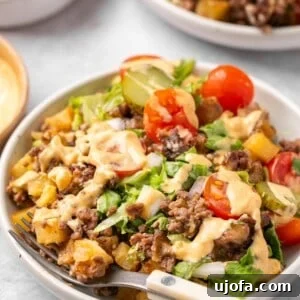 a bowl filled with big mac casserole with a wooden fork