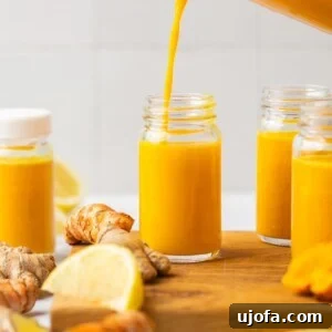 Power-Packed Lemon Ginger Turmeric Shots for Immunity 6 lemon ginger turmeric pineapple shot being poured into a shot glass