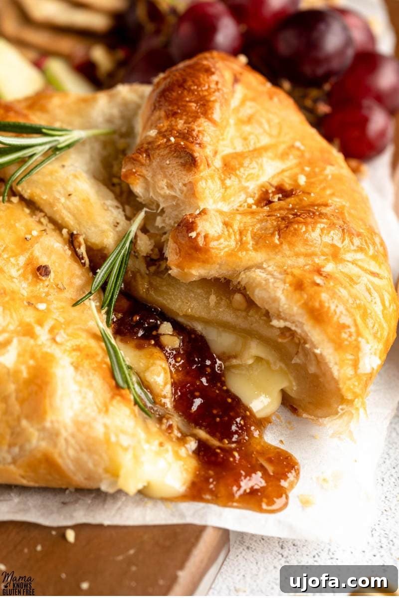 Gluten-Free Baked Brie cut open to reveal cheese and jam filling.