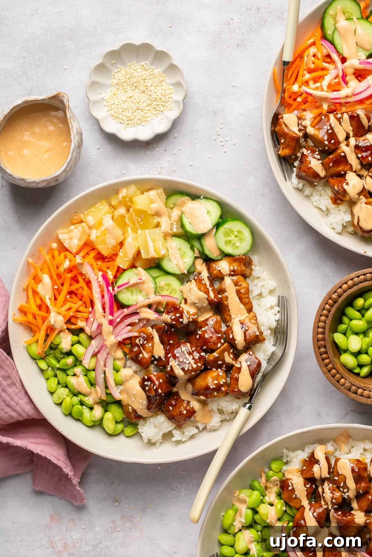 Sweet & Spicy Teriyaki Chicken Poke Bowls 7 chicken poke bowls with toppings surrounded by small bowls of garnishes
