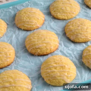 A collection of vibrant gluten-free lemon cookies neatly arranged on a blue cookie sheet, emphasizing their inviting color and zesty appeal.