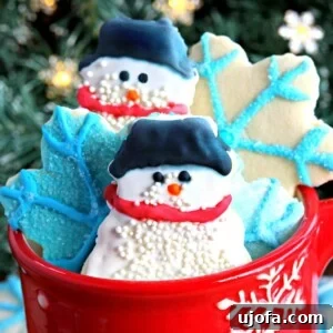 Delightful gluten-free cut-out sugar cookies, shaped as snowmen and snowflakes, presented in a charming red snowflake-patterned cup.