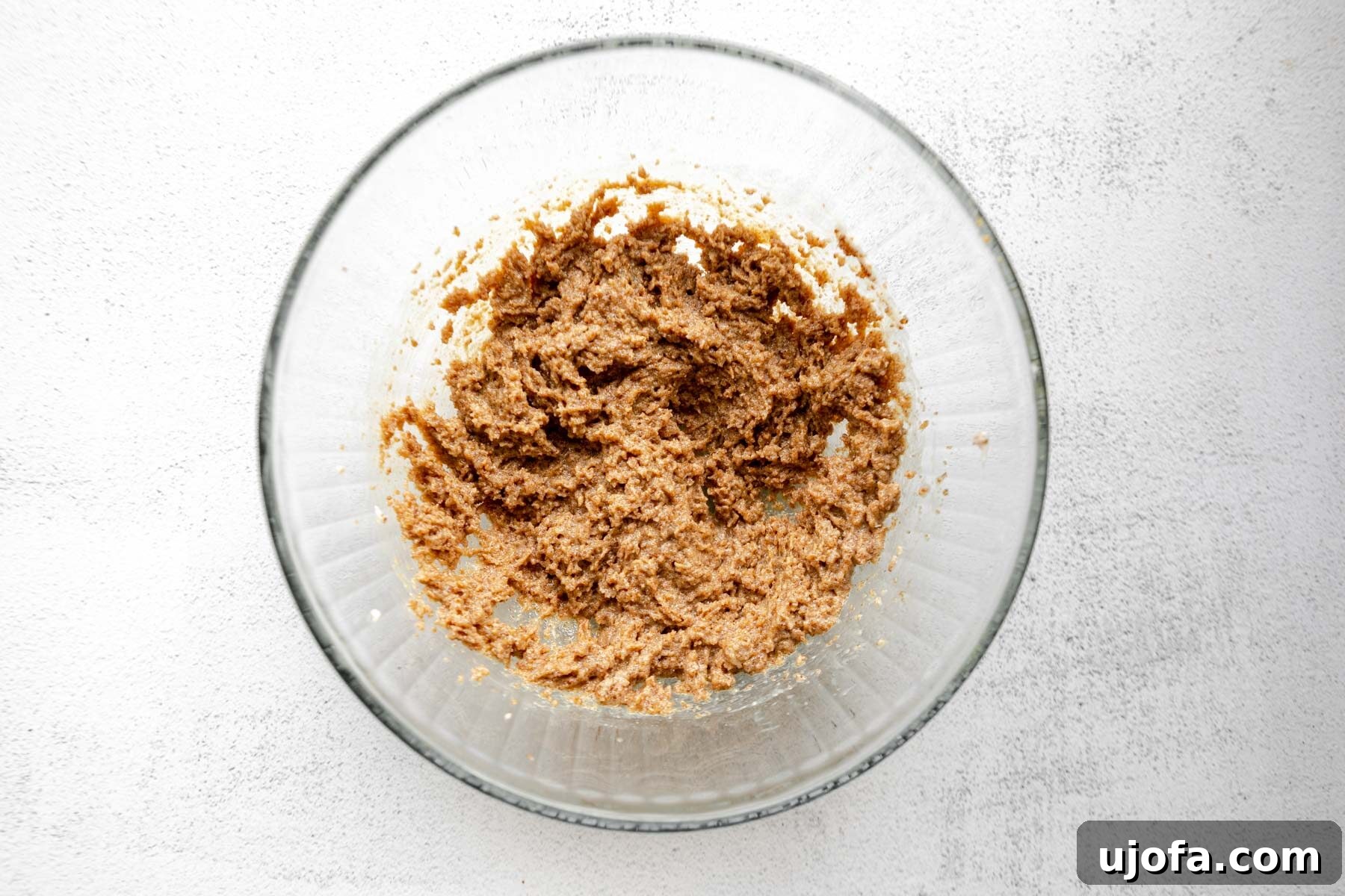 Soft & Chewy Gluten-Free Molasses Spice Cookies 6 Butter and sugar beaten together until creamy and light in a clear glass mixing bowl, illustrating the first step of the recipe.