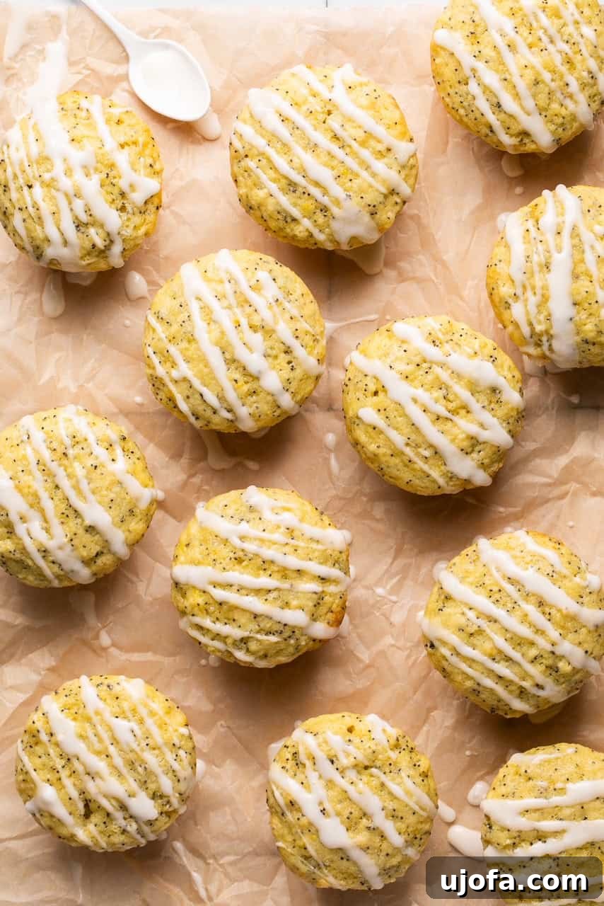 lemon poppy seed muffins on a piece of parchment paper drizzled with glaze