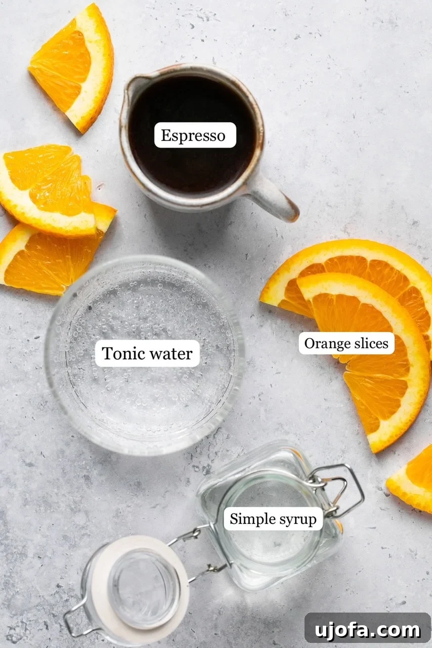 Recipe ingredients labeled on a white surface, showing espresso, tonic water, simple syrup, and orange slices