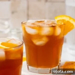 Espresso tonic in a glass garnished with an orange