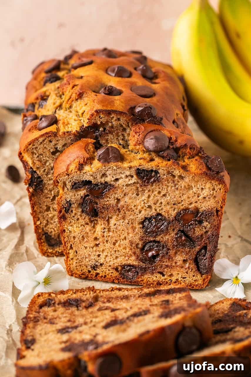 An up-close shot of a sliced protein banana bread, showcasing its moist, fluffy baked middle with melted chocolate chips.