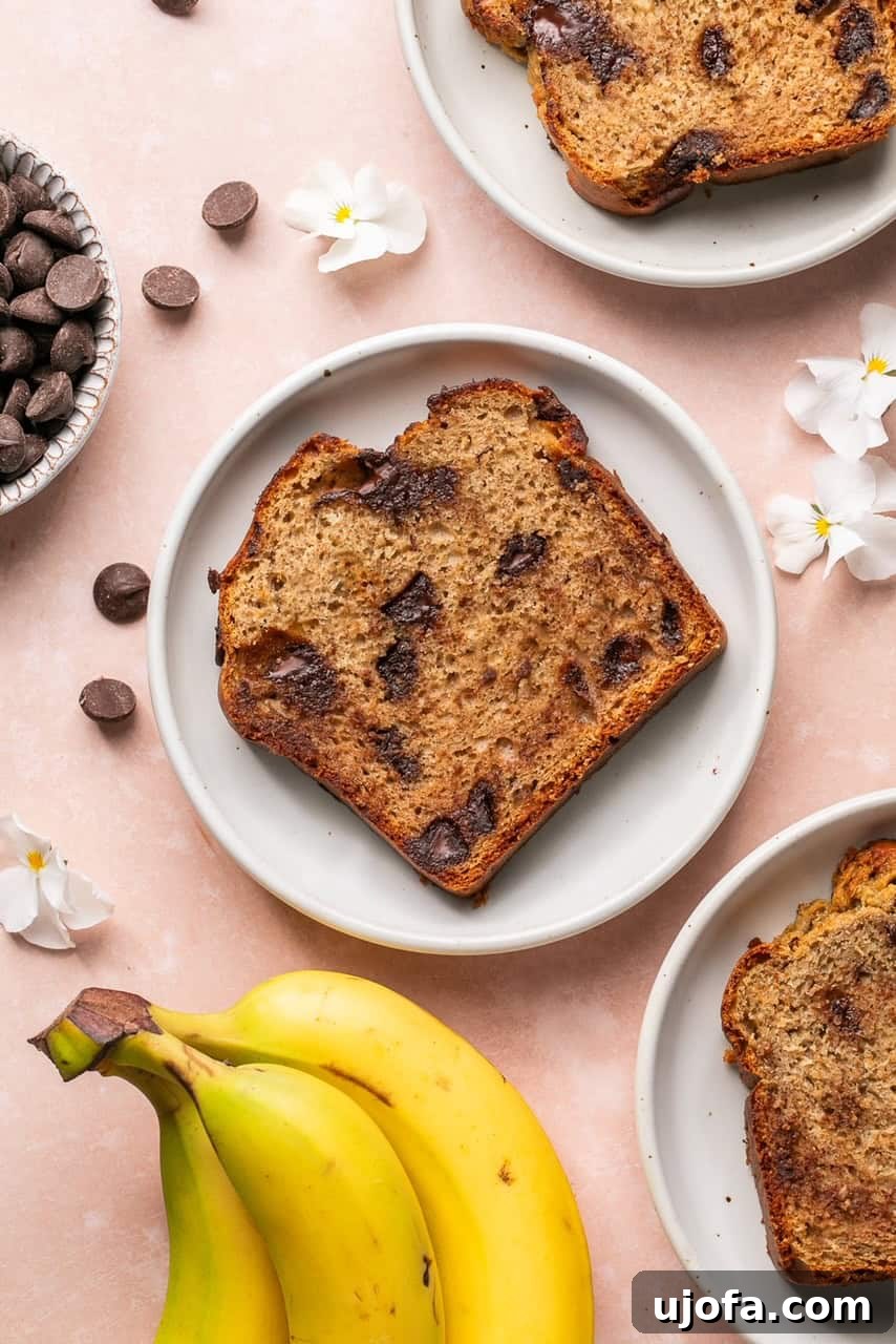 A perfect slice of protein banana bread with visible chocolate chips, served on a white plate.
