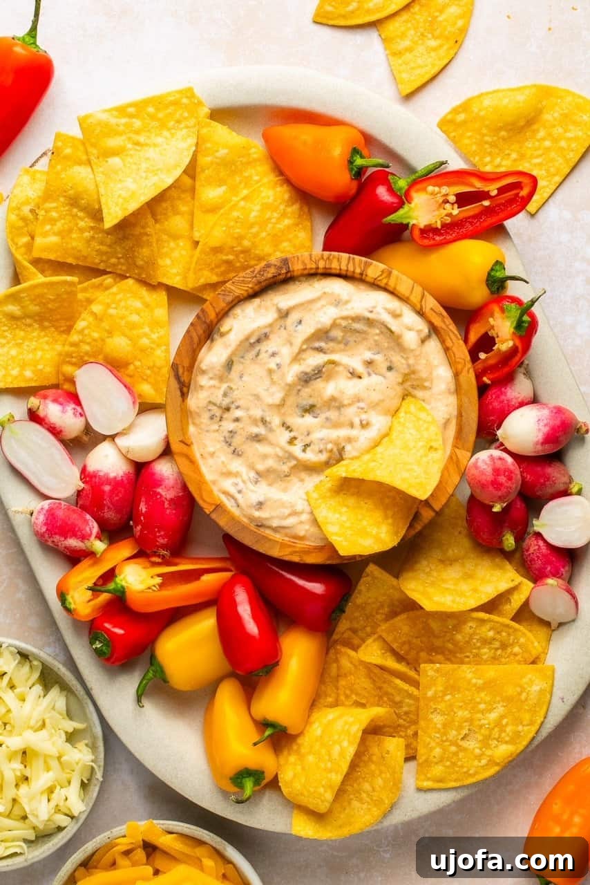 The Viral High-Protein Cottage Cheese Queso: Healthy Dip Perfection 7 an overhead shot of a tray of chips and veggies surrounding a serving bowl filled with queso
