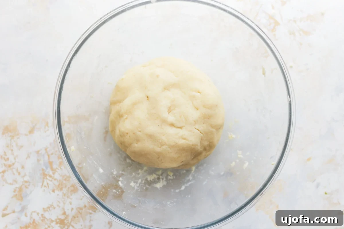 Fluffy Gluten Free Gnocchi 12 smooth gluten free gnocchi dough ball in a glass bowl.
