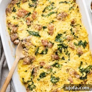 Tuscan Spaghetti Squash Casserole with sausage and kale in a white dish with a spoon